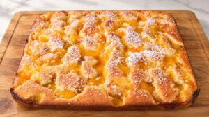 Torta alle pesche soffice con marmellata e granella di mandorle